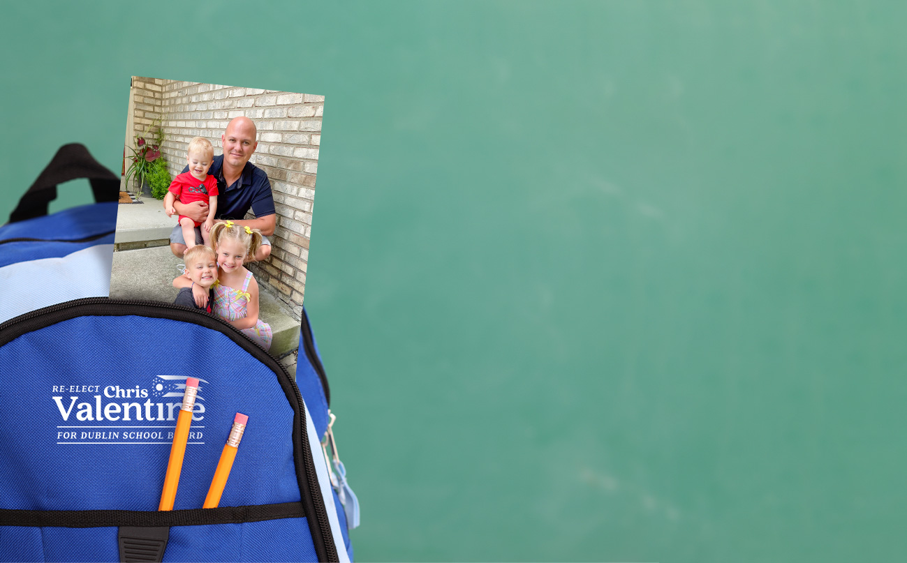 A school backpack in front of a chalkboard with a photo of Chris and his children